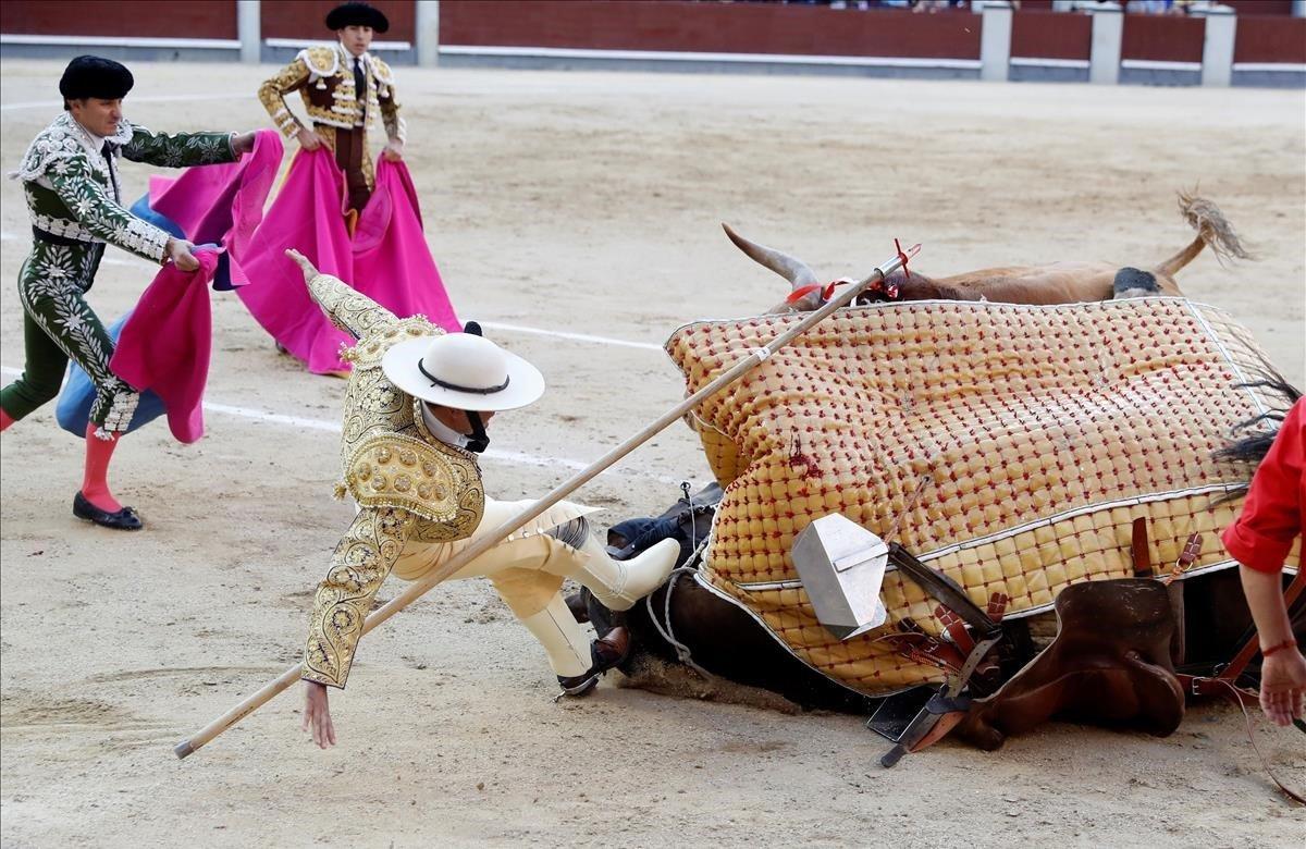 Un picador es derribado durante el vigésimo tercer festejo de la Feria de San Isidro en la plaza de toros de Las Ventas, con toros de las ganaderías de Puerto de San Lorenzo y La Ventana del Puerto.