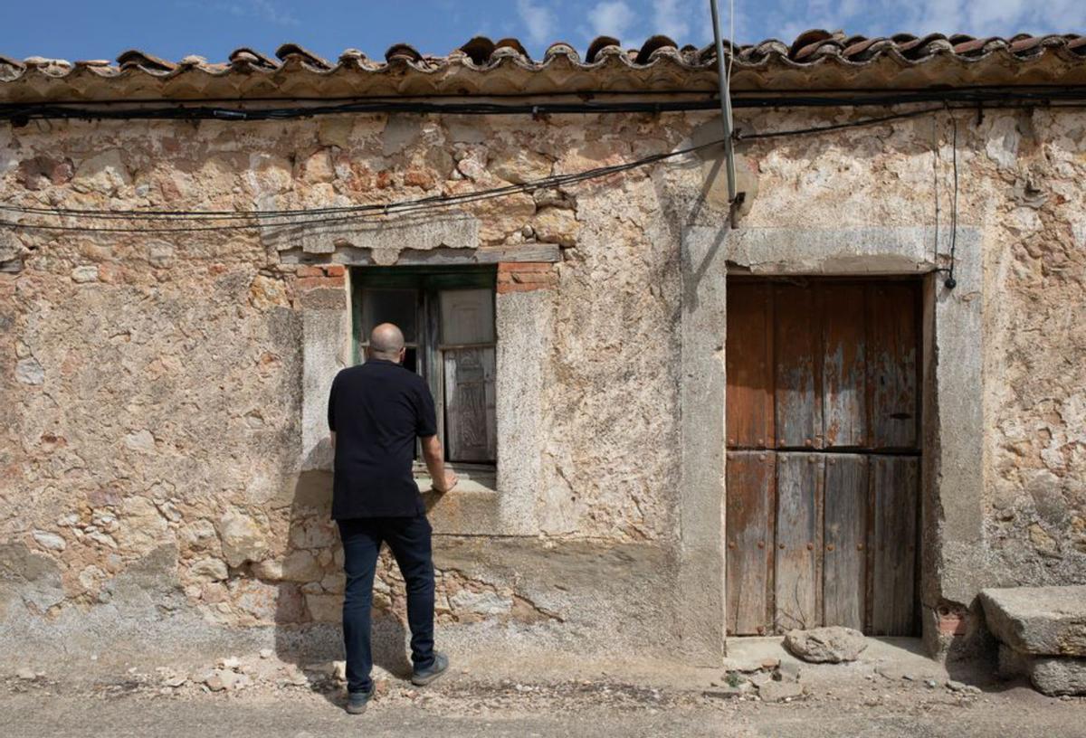 Un hombre se asoma a una casa deteriorada. | Ana Burrieza