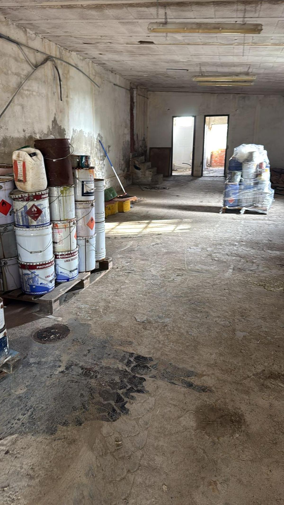 Botes con restos de pintura localizados en el interior. En un lateral, ya embalados para su transporte y posterior tratamiento.