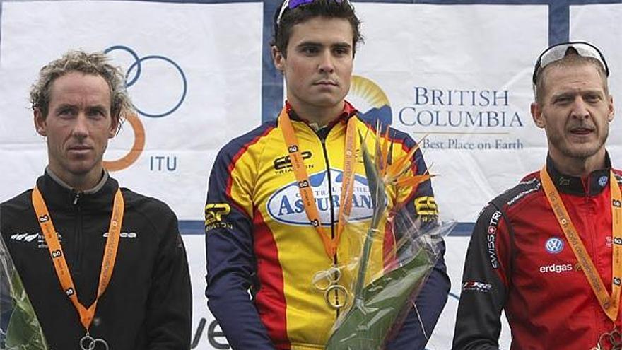 El triatleta gallego Javier Gómez Noya (c) junto al neozelandés Bevan Docherty (i), segundo, y el suizo Reto Hug, tercero, en la ceremonia de entrega de medallas, tras proclamarse esta madrugada en Vancouver (Canadá) campeón del mundo de triatlón, con lo que tras hacerse con la Copa del Mundo tan solo le falta el oro olímpico.