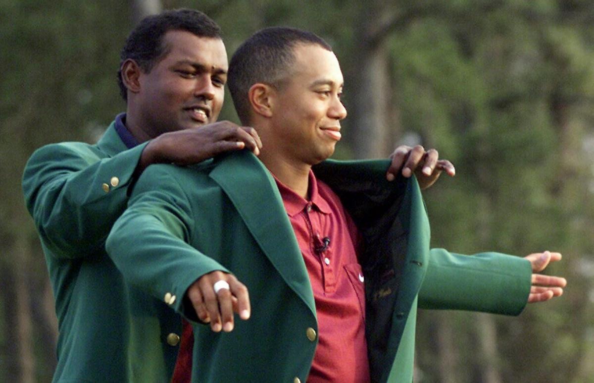 El fidjiano Vijay Sing, ganador en 2003, pone la chaqueta a Tiger Woods, campeón del 2004