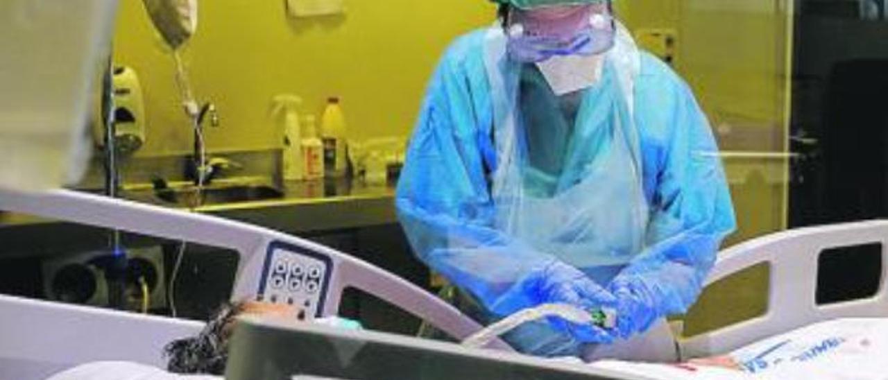 Una sanitaria del Negrín atiende a un paciente con Covid-19 en el UMI.