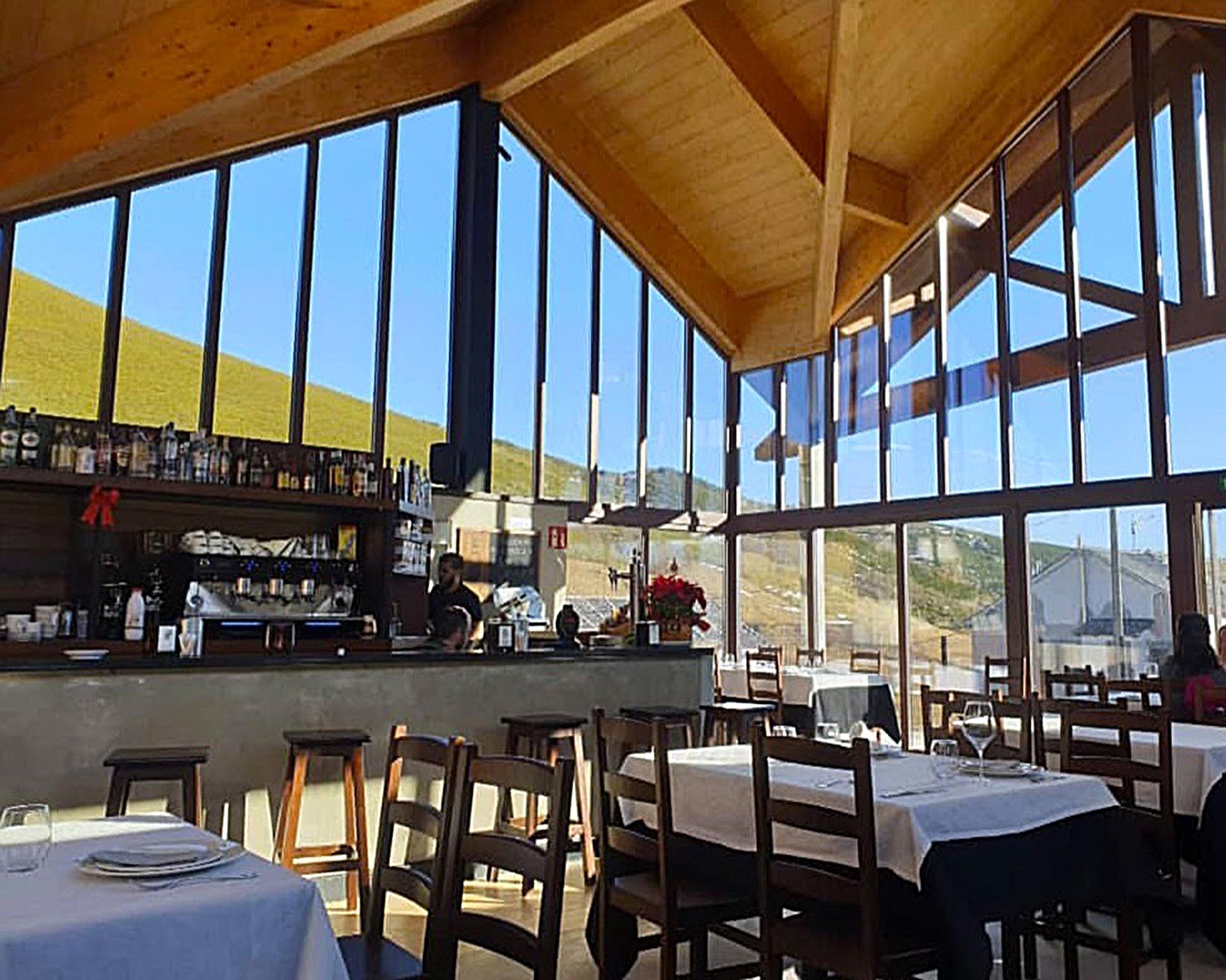 Interior del acristalado comedor, &quot;tomado por el inmenso paisaje del puerto&quot;, tras los cristales.