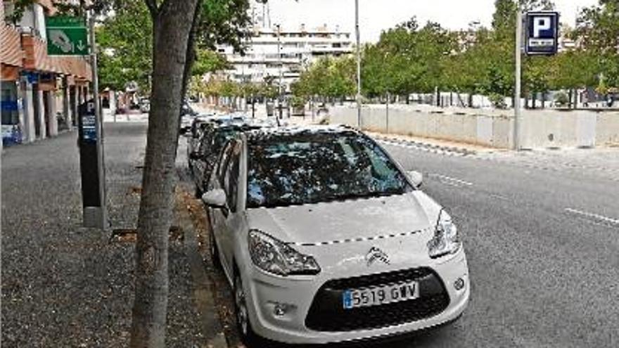 Un cotxe aparcat a la zona verda d&#039;aparcament, al costat de l&#039;estacionament soterrat, al sector del Güell.