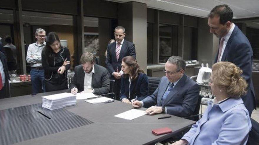 Antonio Asensio, presidente de Grupo Zeta (izqda.), y Javier Moll, presidente de Prensa Ibérica (dcha.), en el momento de la firma de la operación. Arantza Sarasola, vicepresidenta de Prensa Ibérica, a la izquierda de Javier Moll.