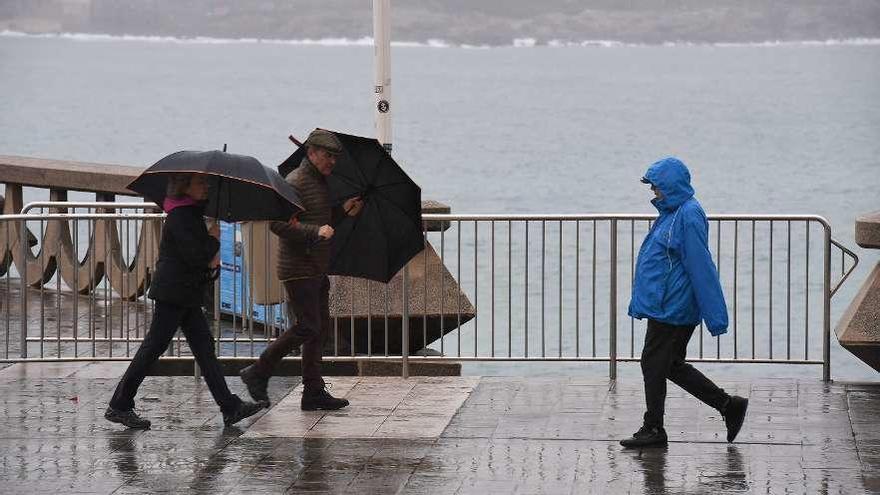 Peatones se protegen de la lluvia en A Coruña.