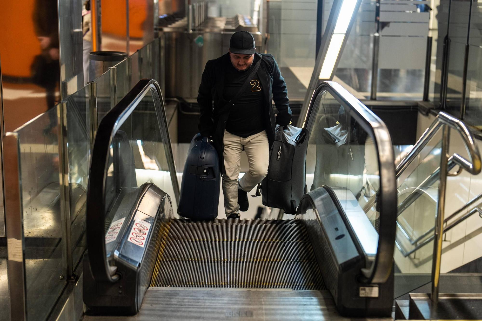 Dioni Delgado sube cargado por las escaleras mecánicas fuera de servicio en la estación de Rodalies de Arc de Triomf, en Barcelona.
