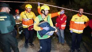 Miembros de Emergencias trasladan a un menor en brazos para ser atendido.