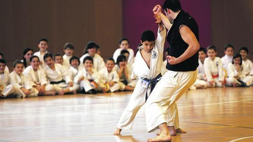 En la foto superior, Iván, de 7 años, simula un combate con Daniel Zurita. Debajo, Inés, también de 7 años, durante su exhibición. / marcos león