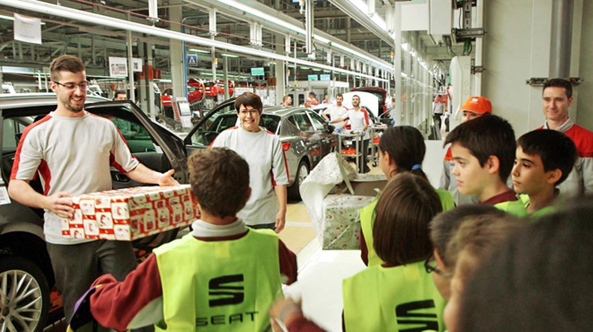 Entrega de regals nadalencs a uns nens en les línies de producció de Seat.