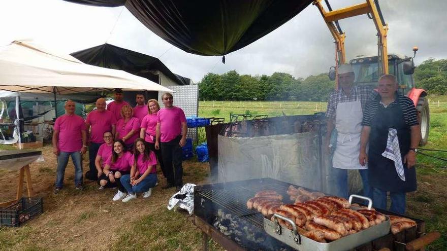 Miembros de la comisión de fiestas y los cocineros, con la carne en proceso.