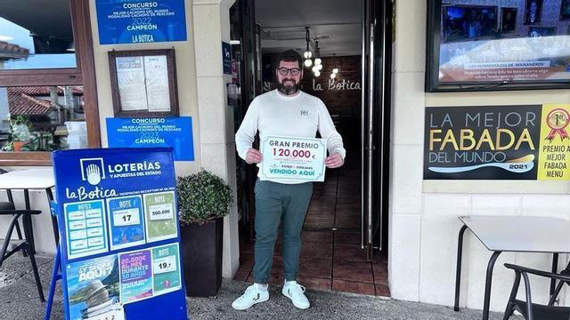 Otto Gutiérrez, propietario del local donde se validó el billete, enseña emocionado el premio.