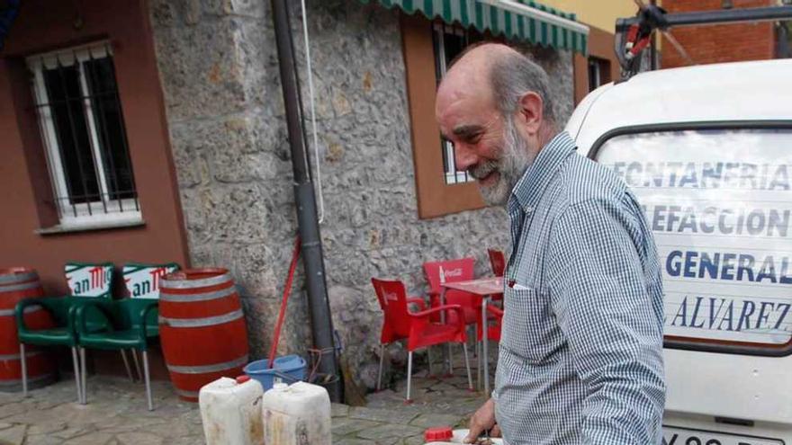 Julián Álvarez, vecino de Palomar, ayer, con unas garrafas de agua.