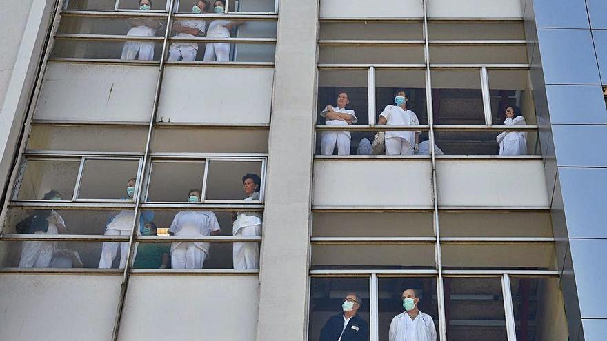 Persoal sanitario do Hospital da Coruña, asomado durante unha homenaxe dos servicios de seguridade.