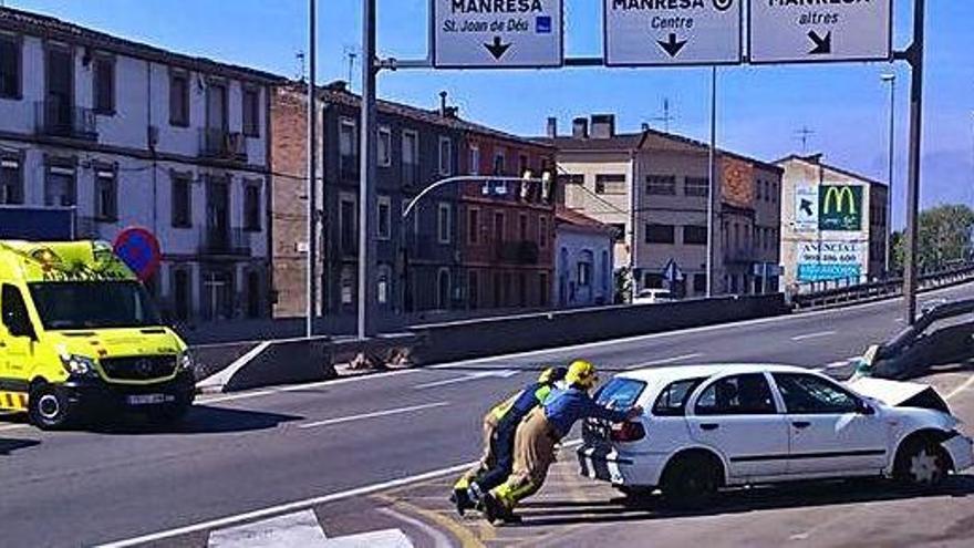 Els bombers retiren de la calçada el vehicle accidentat ahir al matí