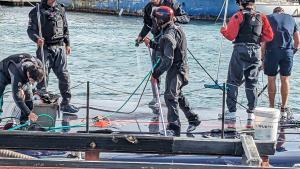 Tareas de limpieza del AC75 del Alinghi Red Bull Racing con agua desalada a su vuelta de los entrenamientos.