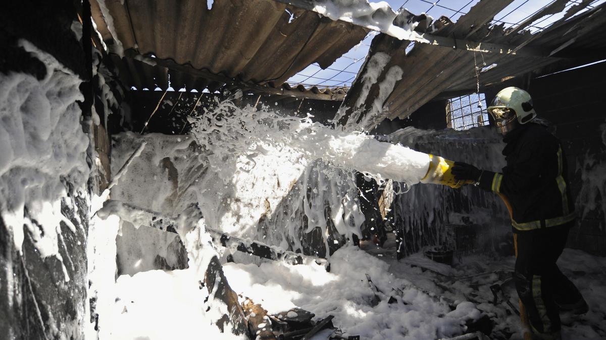 Un bombero refrigera uno de los locales afectados por el fuego. // Bernabé/Javier Lalín