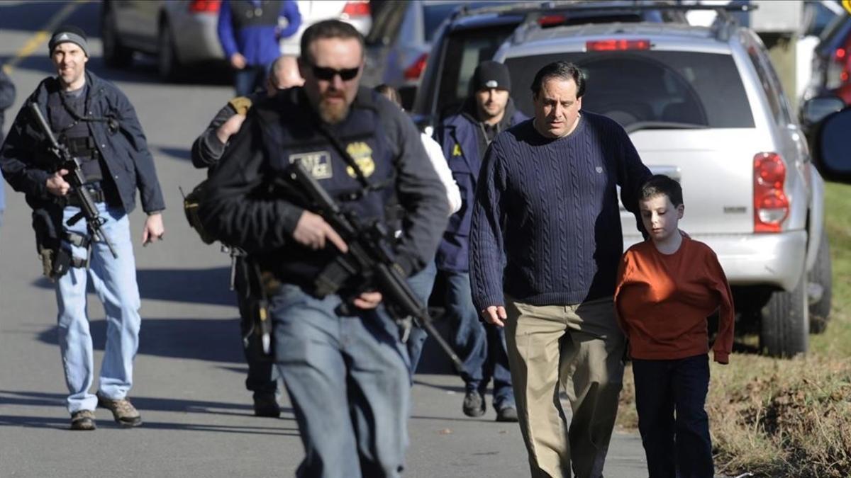 Agentes de policía custodian a padres e hijos de la escuela de Newtown.