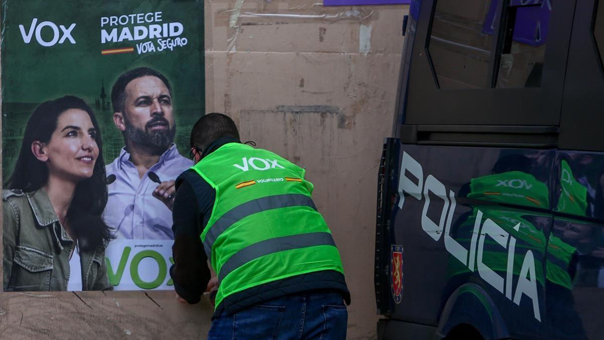 Pegada de carteles electorales de Vox en el marco de un acto electoral del partido en la localidad madrileña de Fuenlabrada a 19 de abril de 2020