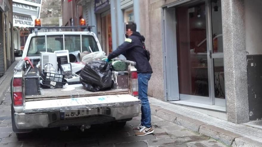 Un agents posa material trobat a l&#039;habitatge en un vehicle de la brigada