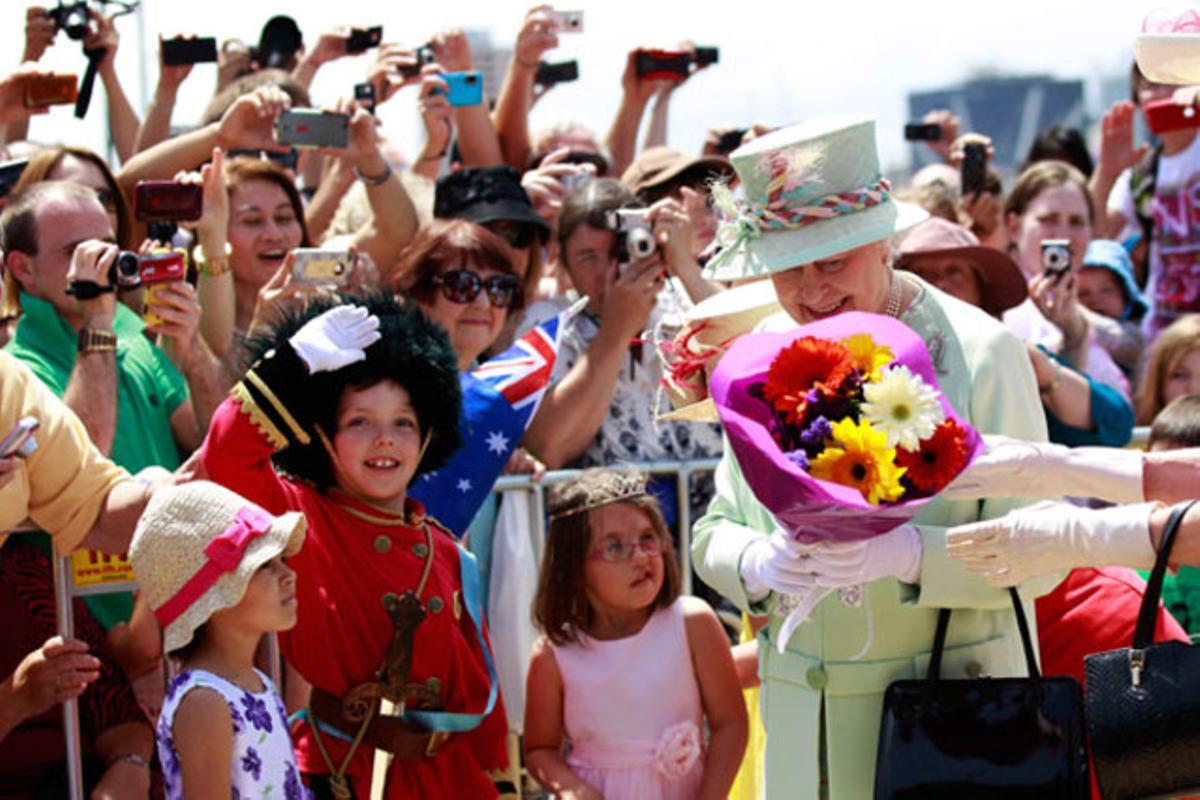 La reina Isabel rep flors d’un grup d’escolars a l’arribar al moll de Southbank, durant una visita oficial a Brisbane (Austràlia).