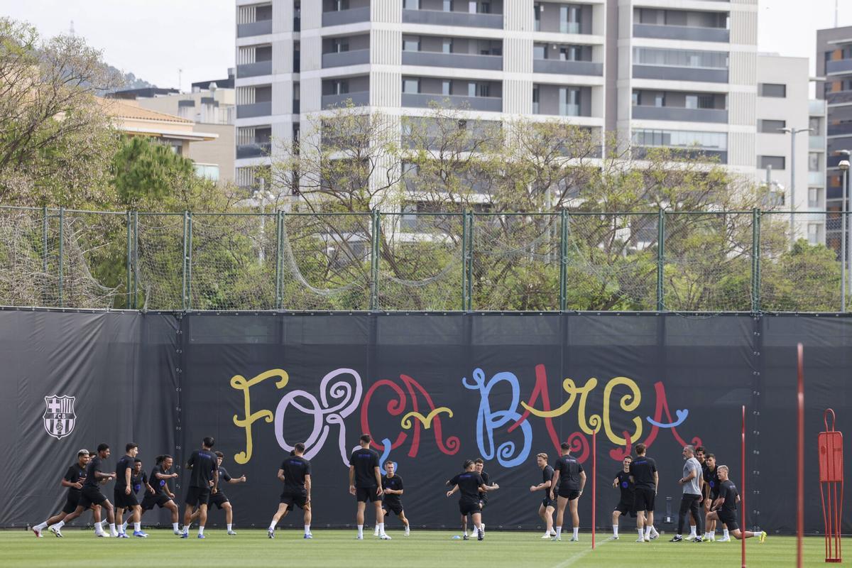 La plantilla del Barça entrena en la ciudad deportiva con un nuevo mural del fondo.