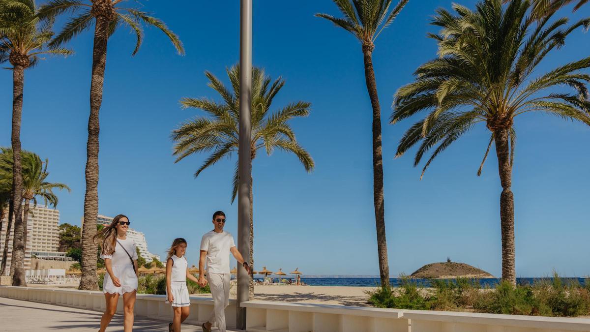Una familia de turistas camina por el paseo marítimo de Magaluf.