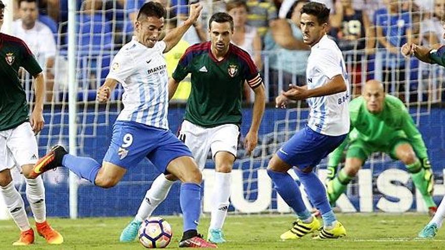 Charles pasa el balón entre Miguel Flaño y David García.