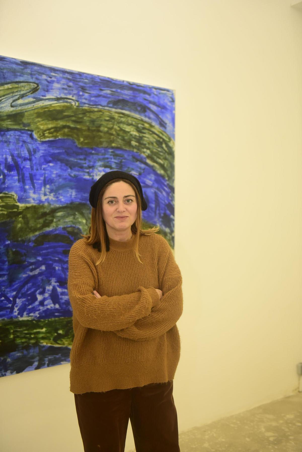 Chus Villar en la galería Nordés ante una obra de Miguel Marina