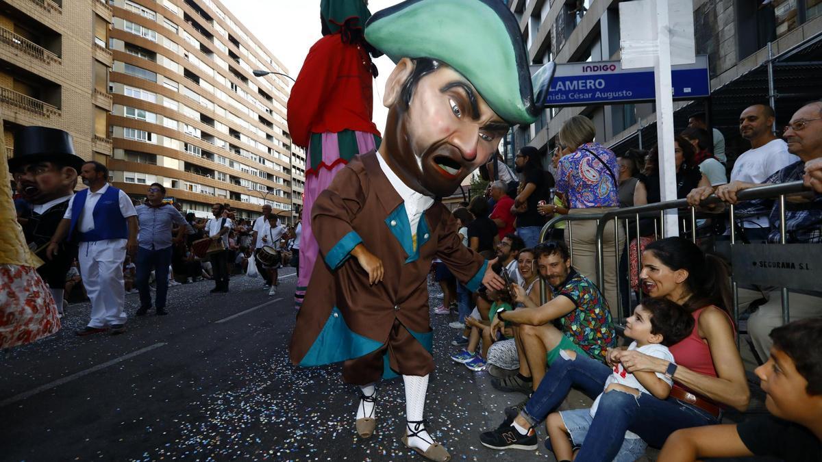 Un cabezudo saluda a un niño en el desfile del Pregón por las calles del centro de Zaragoza