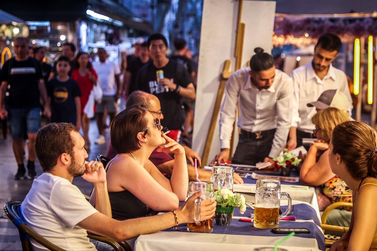 Unos turistas toman unas consumiciones de gran tamaño en la Rambla.