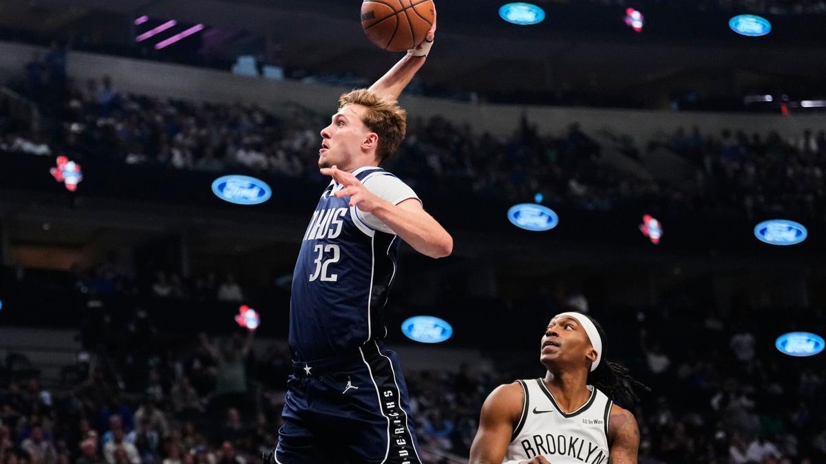 Dallas Mavericks forward Cooper Flagg (32) leaps to the basket to dunk after getting past Brooklyn Nets guard Terance Mann (14) in the first half of an NBA basketball game in Dallas, Friday, Dec. 12, 2025. (AP Photo/Tony Gutierrez)