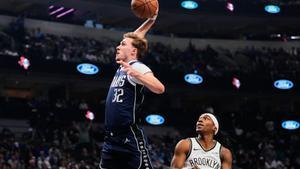 Dallas Mavericks forward Cooper Flagg (32) leaps to the basket to dunk after getting past Brooklyn Nets guard Terance Mann (14) in the first half of an NBA basketball game in Dallas, Friday, Dec. 12, 2025. (AP Photo/Tony Gutierrez)