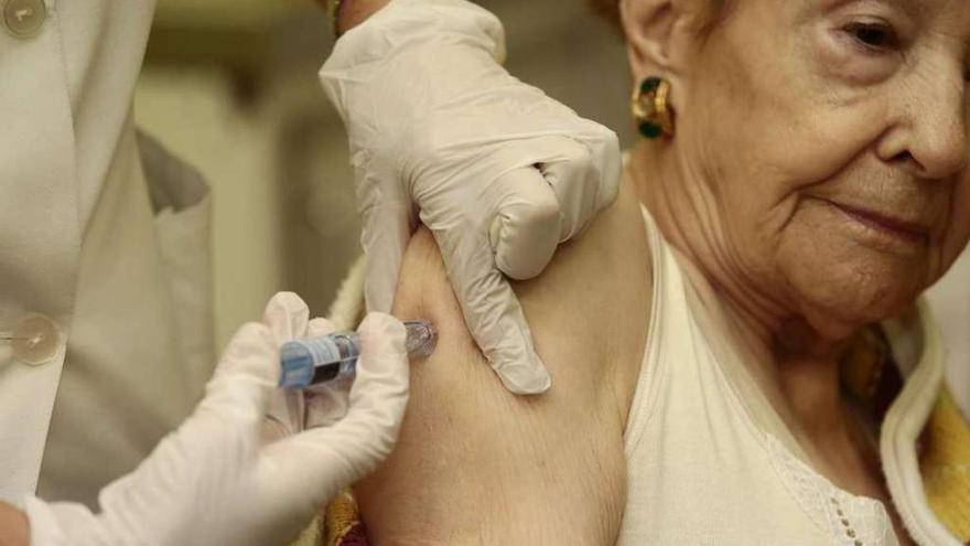 Una sanitaria vacuna a una mujer en un centro de salud gallego. adrián irago