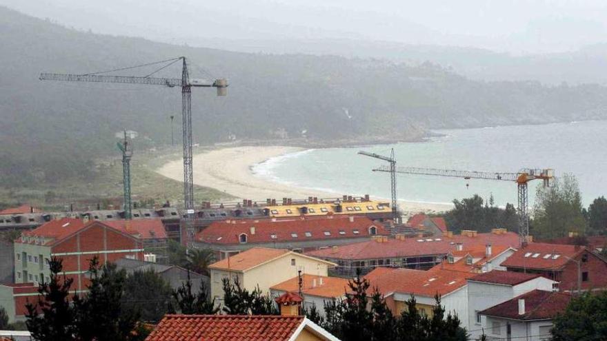 Grúas en varias viviendas en construcción durante el &#039;boom&#039; inmobiliario en la costa de Fisterra.