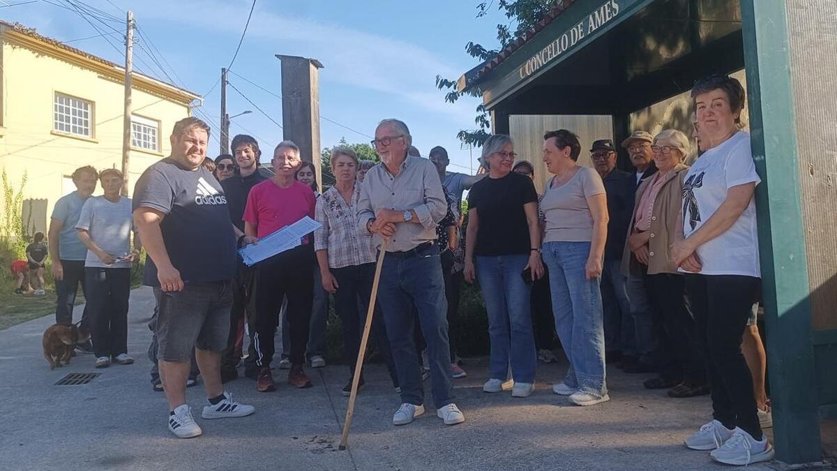 Algunos vecinos de Ames perjudicados por la falta de parada del P2 en esta marquesina de A Moniña con las firmas