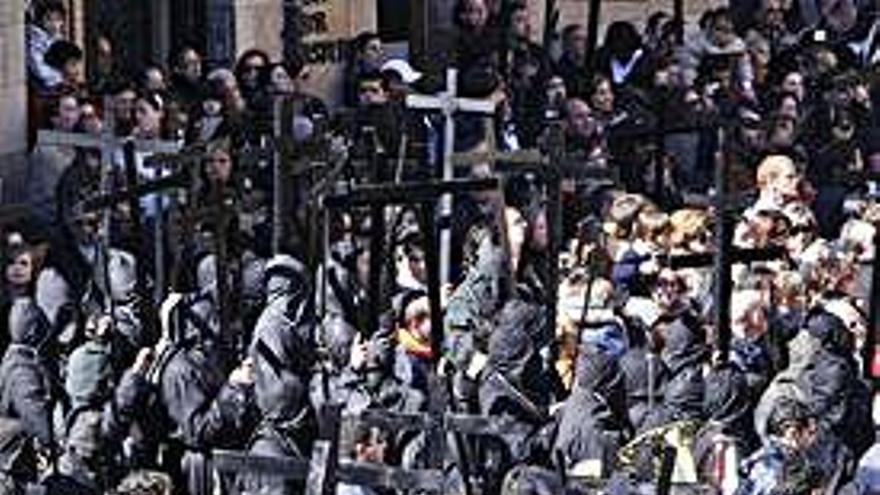 Congregantes alzan sus cruces en la despedida a la Soledad la mañana del Viernes Santo.