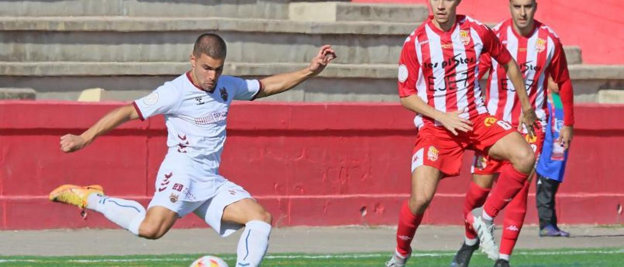 Ángel Bastos se dispone a dar un pase ante la mirada de los defensas del Manresa.