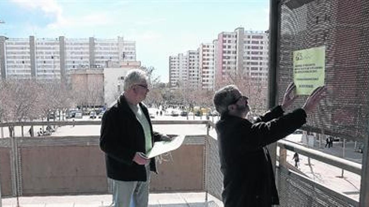 Tejido asociativo fuerte 8 Dos miembros de la asociación de vecinos de Bellvitge colocan un cartel reivindicativo en las inmediaciones del local de la entidad, ayer por la mañana.