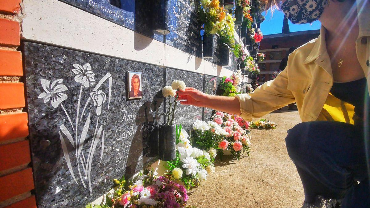 Una vecina arregla las flores de la lápida de su ser querido fallecido en el cementerio de Vila-real.