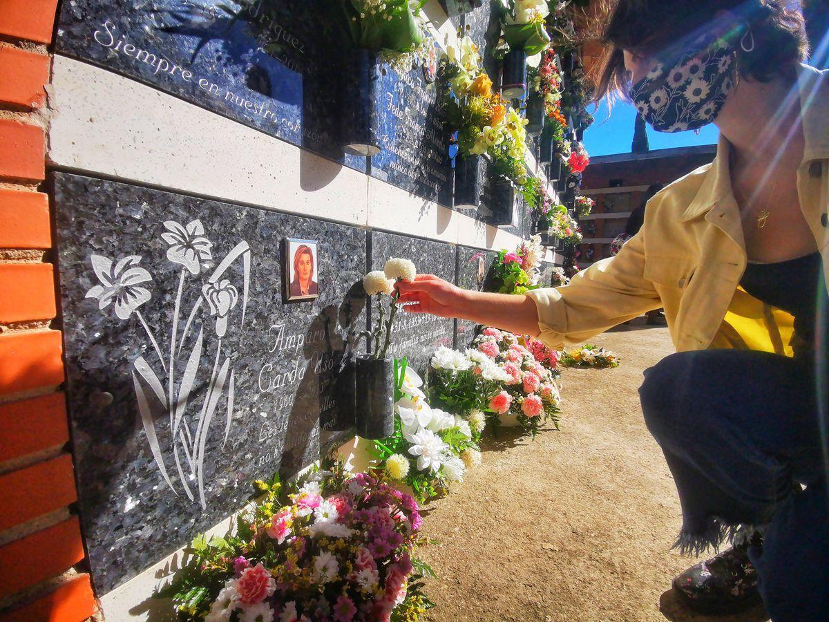 Una vecina arregla las flores de la lápida de su ser querido fallecido en el cementerio de Vila-real.