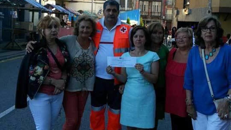 En el centro de la imagen, la concejala tinetense Mayte Ruiz con el cheque, acompañada por miembros de Cruz Roja y de la Asociación de Amas de Casa de Tineo.