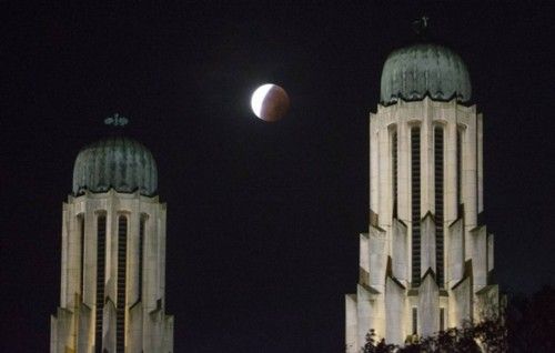 The Koekelberg Basilica is seen while the moon turns orange during a total "supermoon" lunar eclipse in Brussels