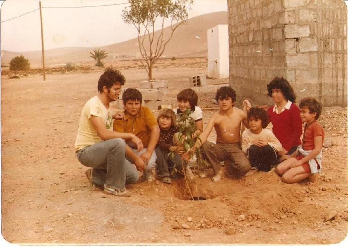 Imagen del maestro Fernando Pérez  Vega con sus siete alumnos de Las Parcelas plantando árboles en el colegio, en 1981.