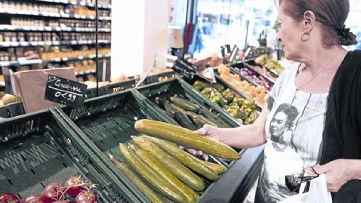 Cesta de la compra 8 Una mujer escoge verduras en un supermercado de París.