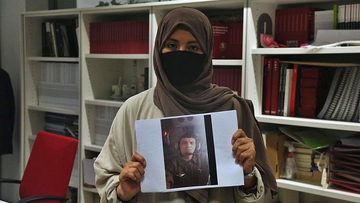 La dona del dissident deportat mostrant la seva fotografia. | ACN