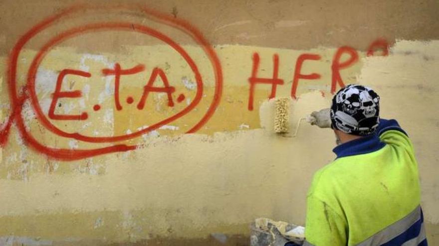 Un empleado municipal de Guernica borra una pintada de ETA. / reuters