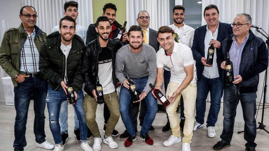 David Martín, atrás, con los jugadores y directivos del Avilés, durante la presentación del vino.