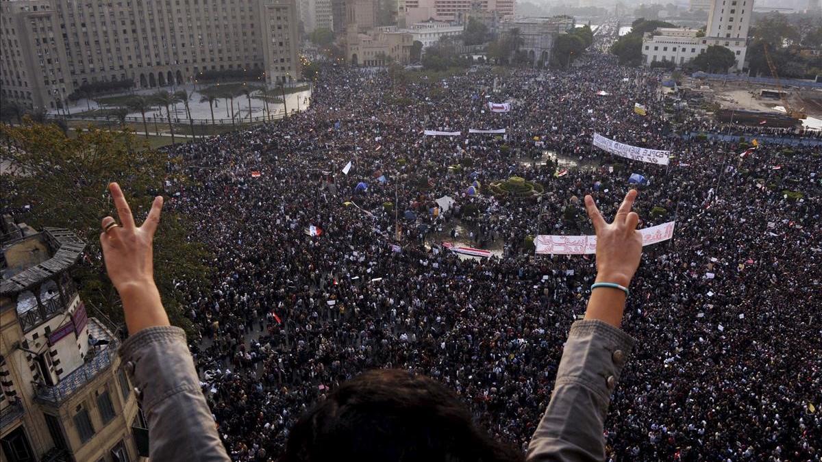 LIO30 EL CAIRO (EGIPTO)  1 2 2011 - Una mujer hace el signo de la victoria delante de miles de personas que participan en la  marcha del millon   una concentracion en la que se espera que acudan un millon de personas  en la plaza Tahrir de El Cairo  Egipto  hoy  martes 1 de febrero de 2011  Una marea humana de mas de 100 000 personas  segun fuentes de la seguridad  abarrota la plaza y decenas de miles mas colapsan las calles aledanas  que siguen recibiendo a gente pese a que esta a punto de entrar en vigor el toque de queda en Egipto  Los manifestantes exigen la dimision inmediata del presidente egipcio  Hosni Mubarak  y la convocatoria de elecciones libres  EFE Andre Liohn