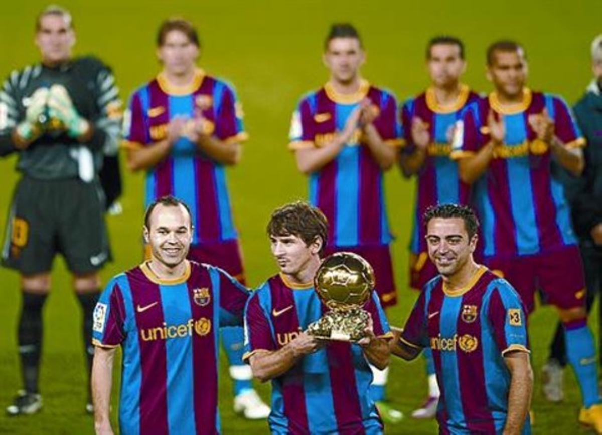 Iniesta y Xavi secundan a Messi con el trofeo en el Camp Nou.